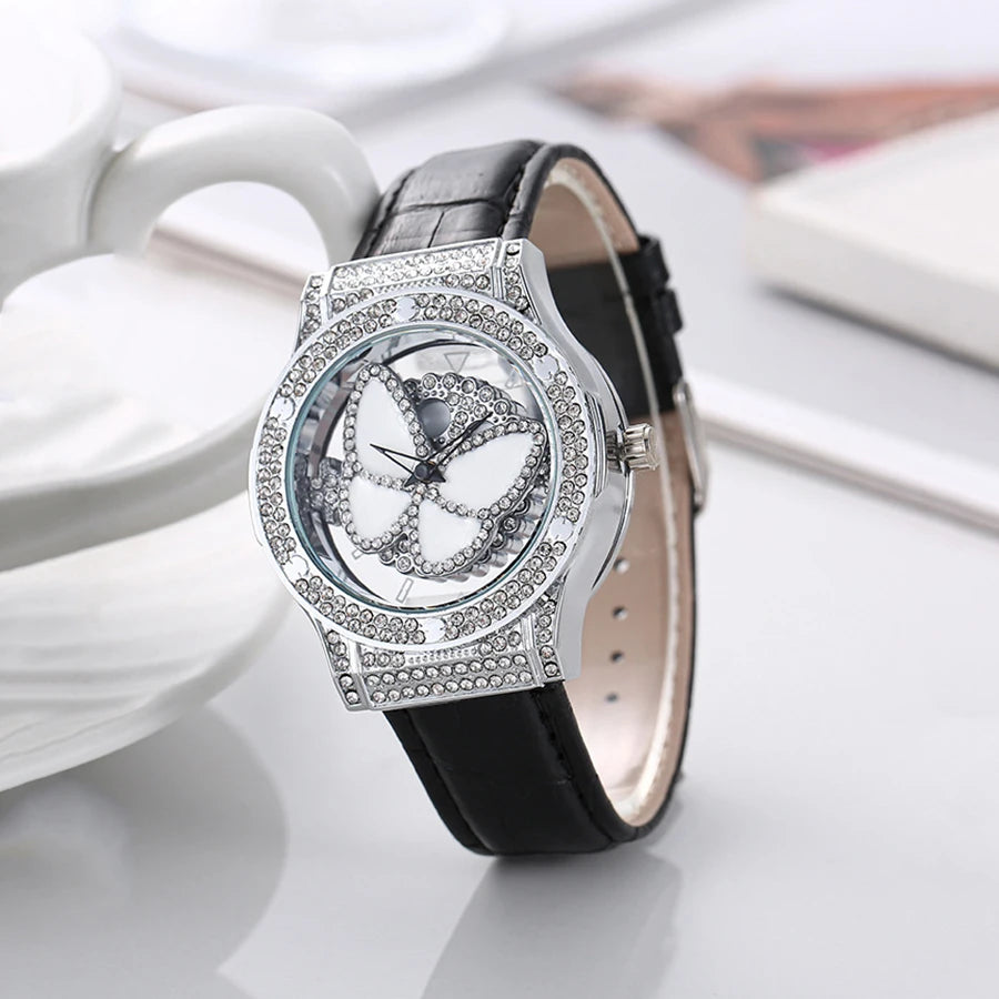Reloj de cuarzo de cuero con diamantes de imitación de cristal brillante y mariposa giratoria para mujer a la moda