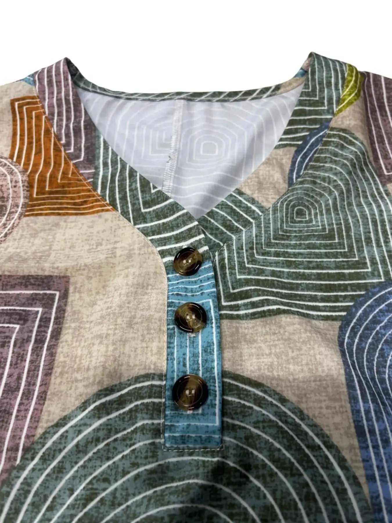 Vestido ajustado hasta la rodilla con estampado geométrico de bloques de color, cuello en V y botones